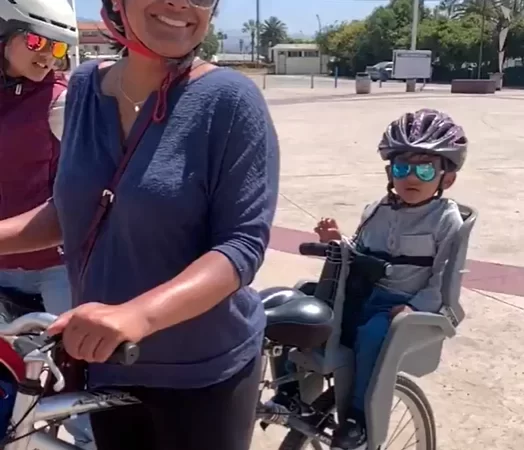 a kid on a bike with mom